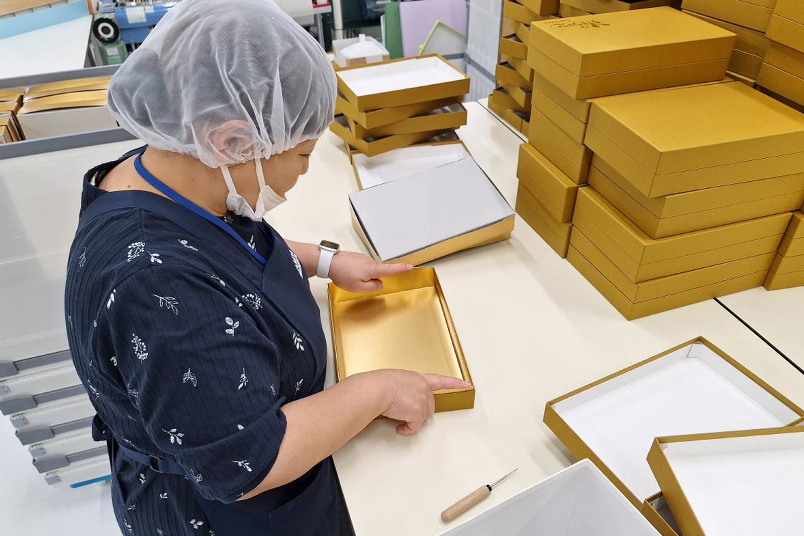 Inspecting a gold rigid box in the sample workshop