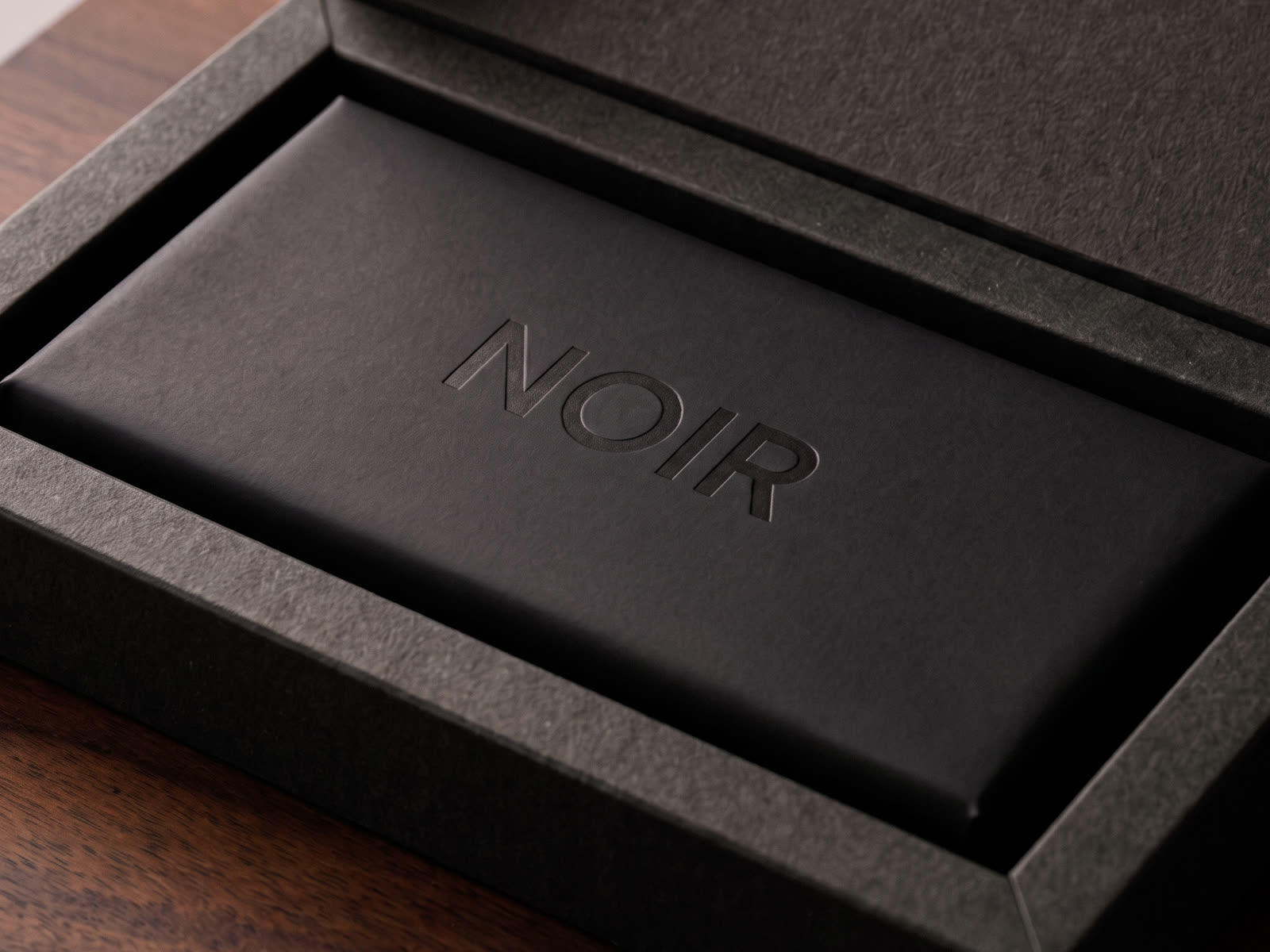 Matte black rigid box with debossed wordmark