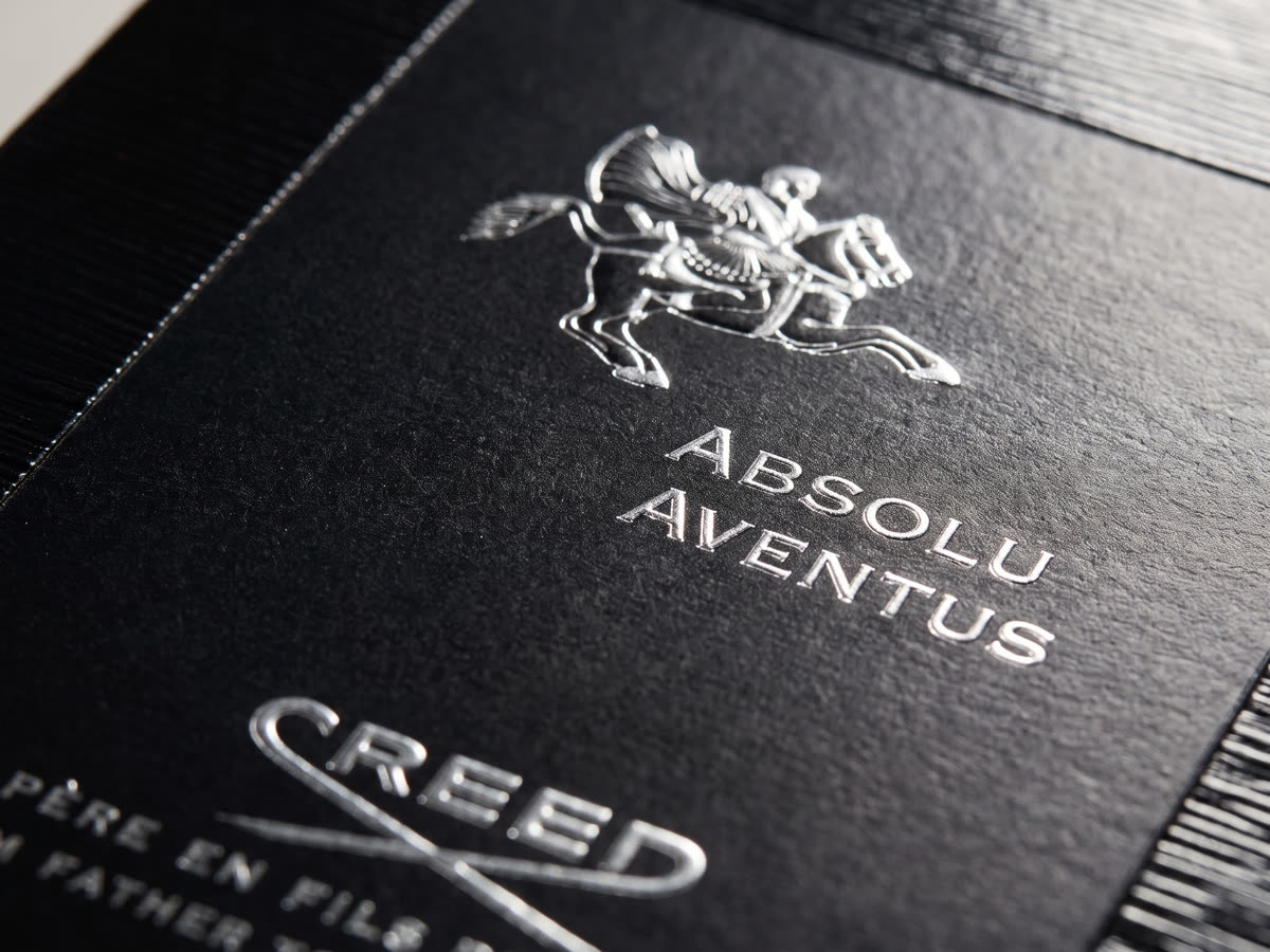 Macro of a foil-stamped fragrance box, embossed crest detail