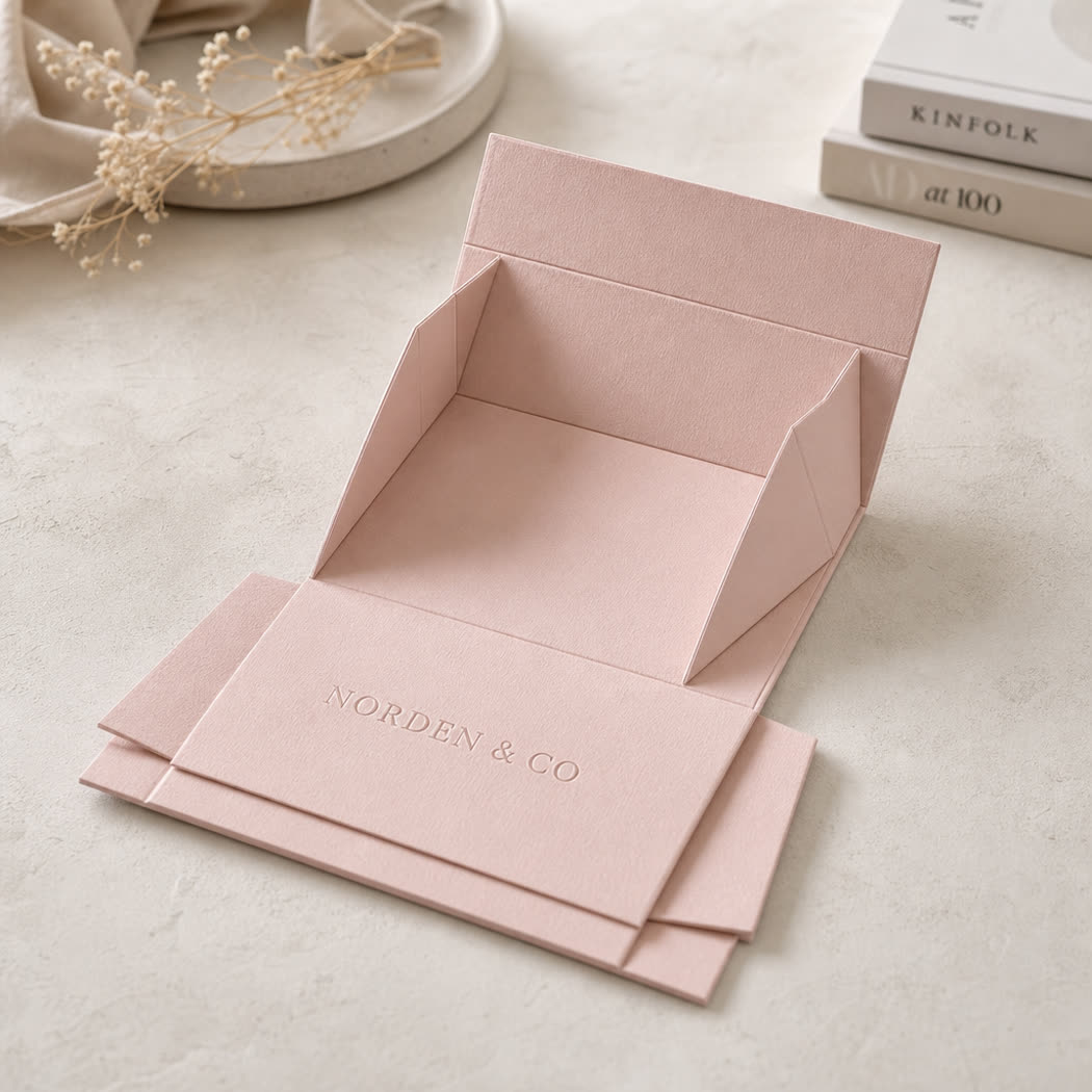 Collapsible fashion carton shown partially folded flat