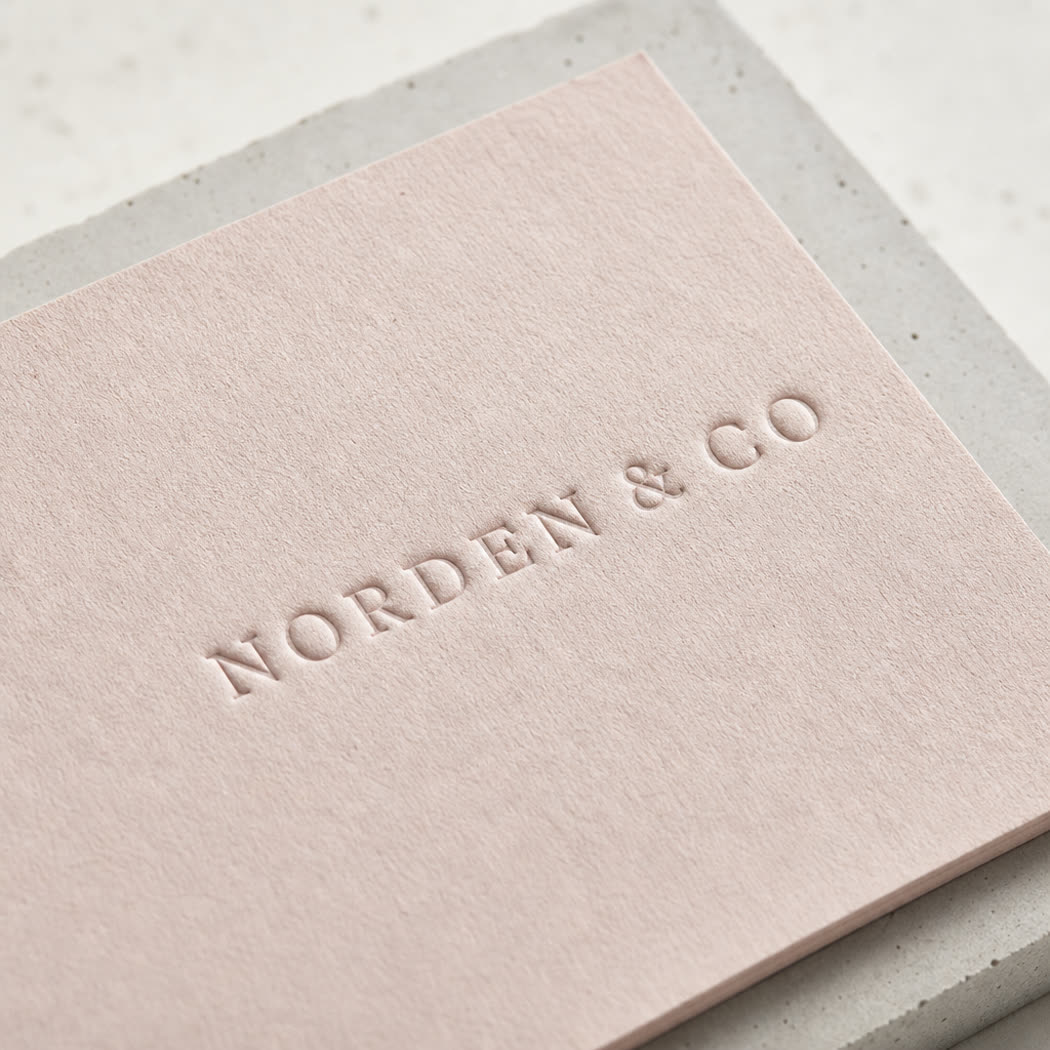 Macro detail of a debossed logo on uncoated board
